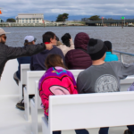 a group of people enjoy the knowledge shared by Monterey Bay Eco Tours naturalist aboard their tour.