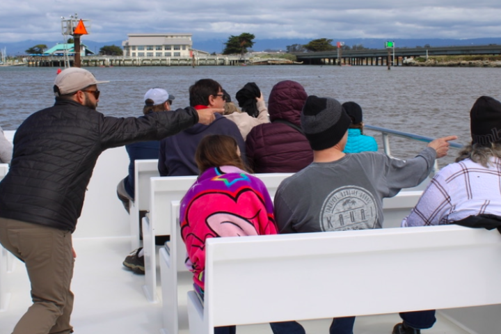 a group of people enjoy the knowledge shared by Monterey Bay Eco Tours naturalist aboard their tour.