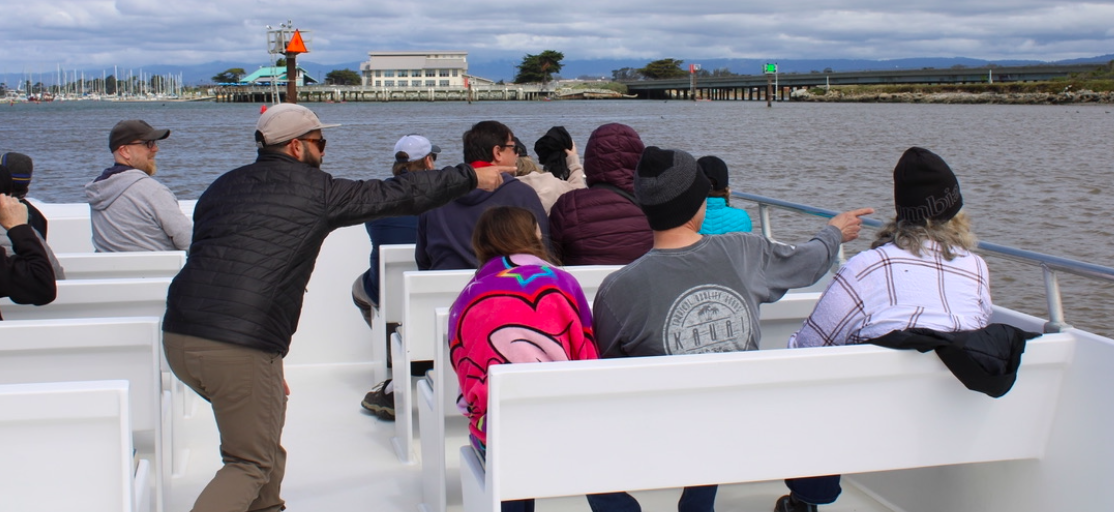 a group of people enjoy the knowledge shared by Monterey Bay Eco Tours naturalist aboard their tour.